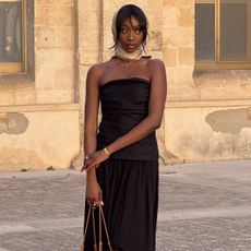 Emmanuelle wears a headscarf, black strapless dress, and loewe tote bag.