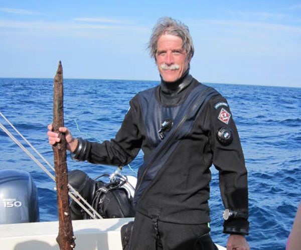 Wooden Artifact From Lake Huron. Anthropologist John O&#039;Shea stands next to a peice of wood, thought to be a prehistoric tool, recovered from the bottom of Lake Huron. 