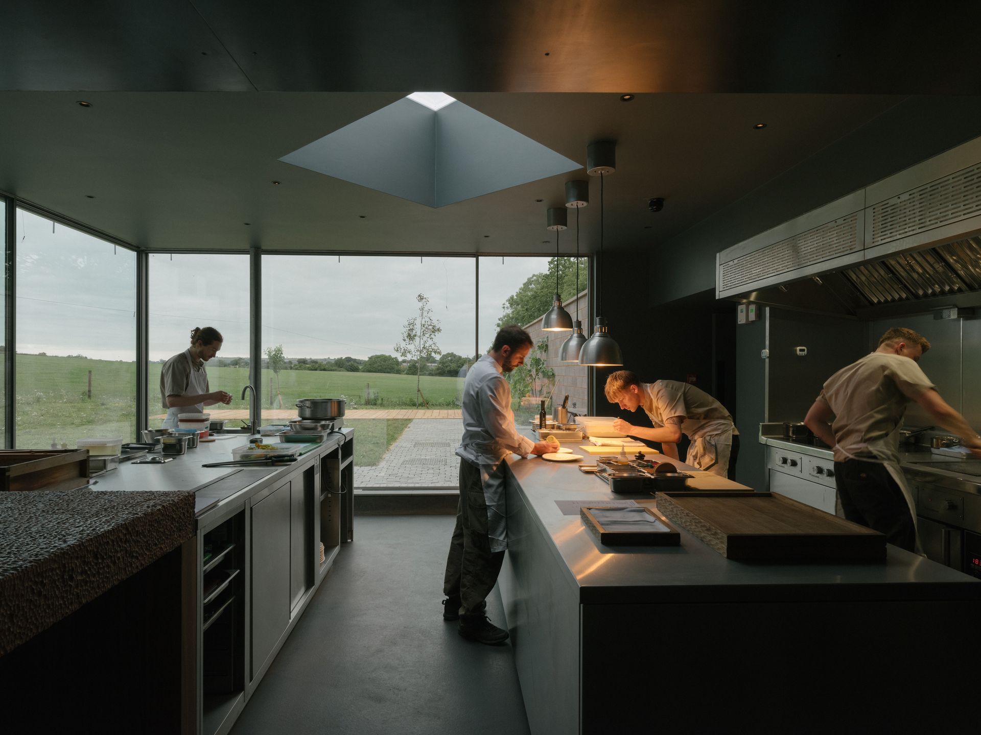 chefs at work in kitchen with fields outside