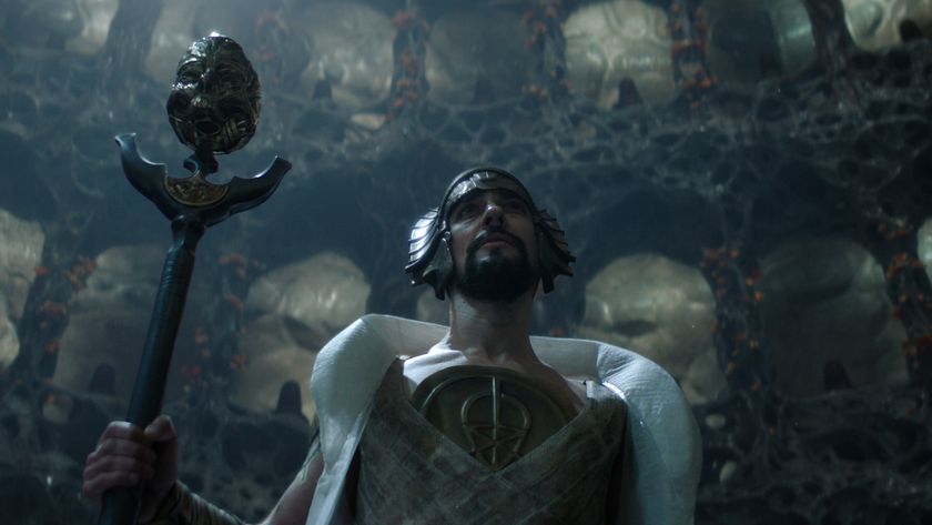  a priest-like figure hold a staff topped by a severed robot head