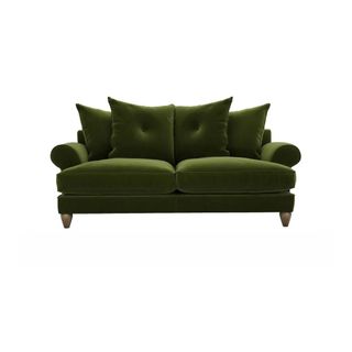 A green velvet sofa with scatterback cushions and turned wood feet