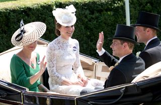 Duchess Sophie wearing a green dress and waving while riding in a carriage with Kate Middleton wearing a white dress and Prince Edward and Prince William in top hats and tails