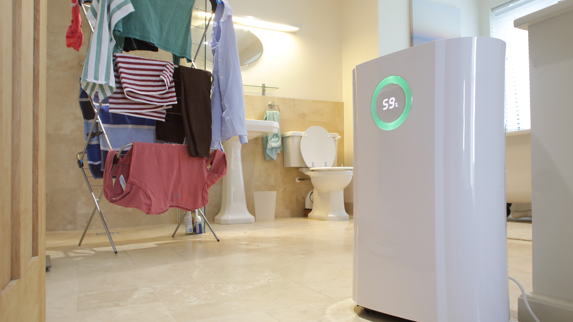 Dehumidifier in bathroom next to drying clothes