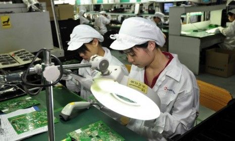 Workers at the Foxconn plant in Shenzhen, China: The tech manufacturer&amp;#039;s employees will now receive money for unpaid overtime hours and will only be able to work a set number of hours per wee