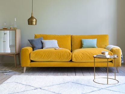 living room with yellow velvet sofa by loaf