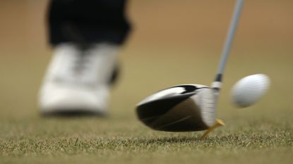 Close-up of a club hitting a ball off a tee