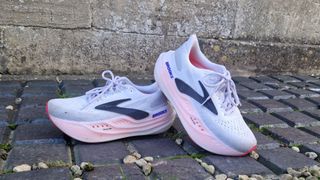 A pair of Brooks Glycerin Max shoes on a gravel and tile pathway