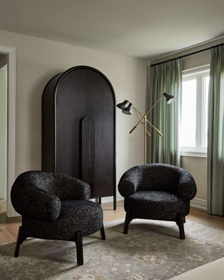 a green bedroom with black chairs and wardrobe