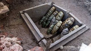 A box containing stone figurines depicting humans.