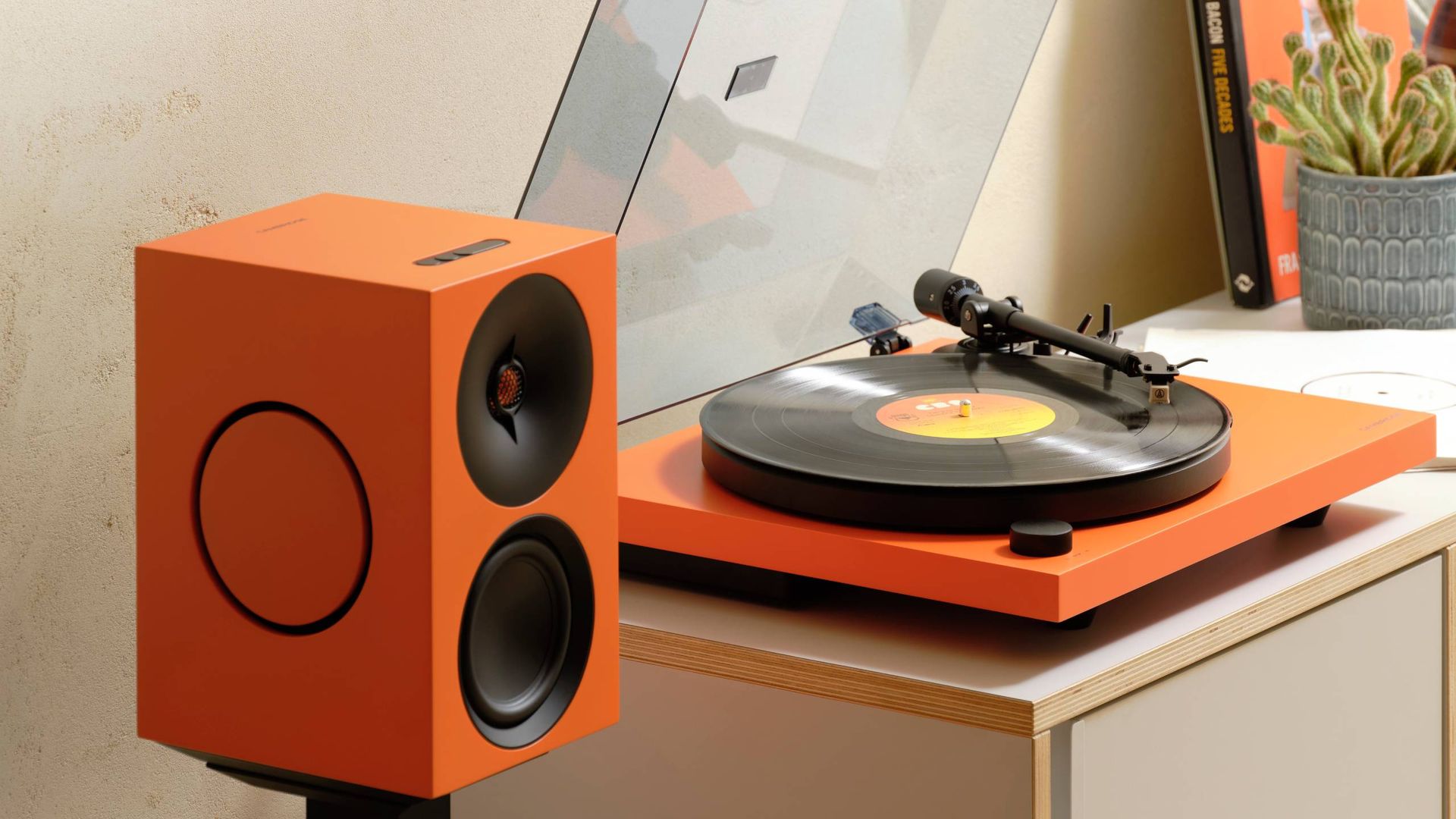 The Cambridge Audio Spira next to an orange speaker.