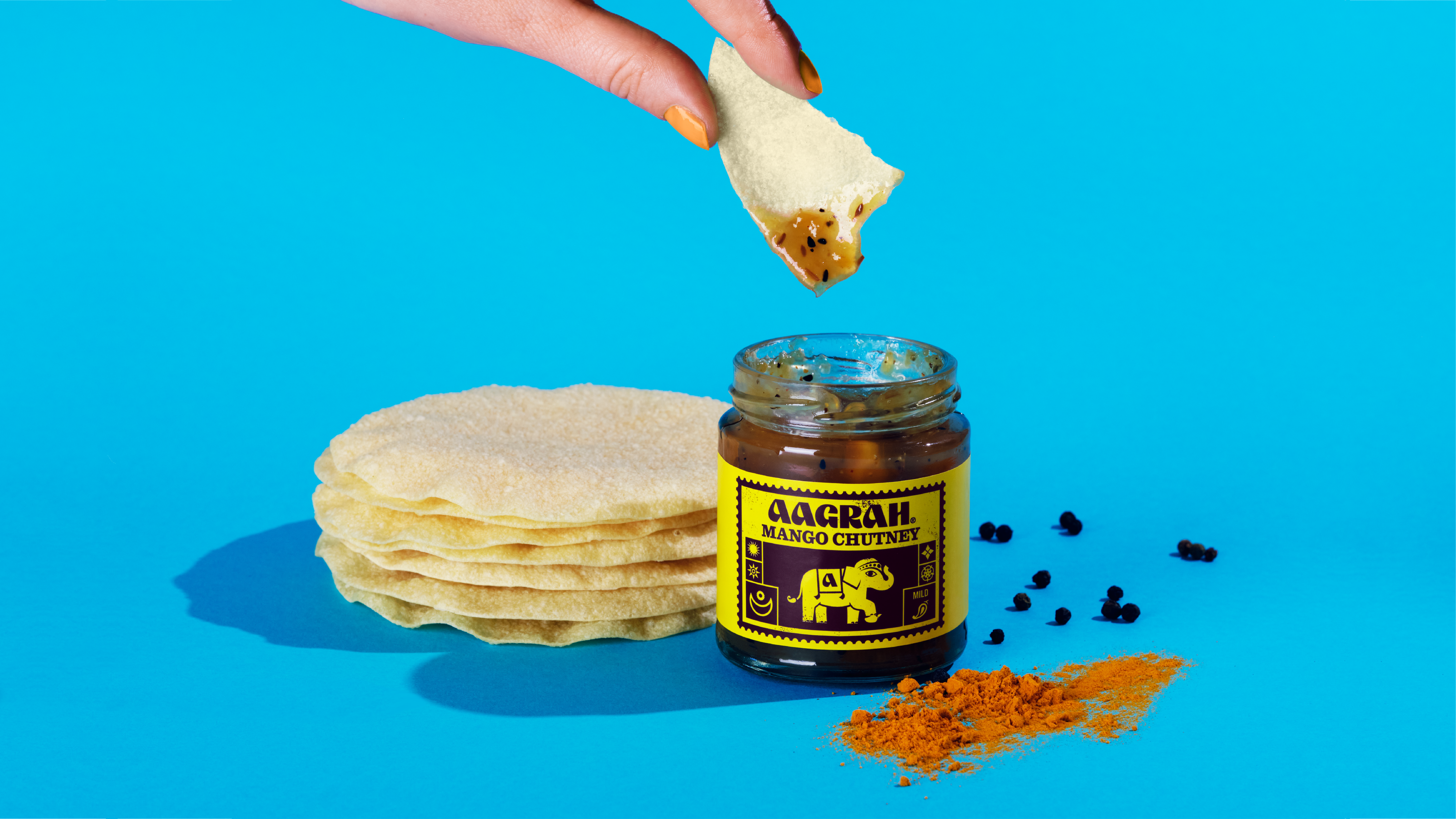 Aagrah foods chutney with someone dipping a poppadom in it