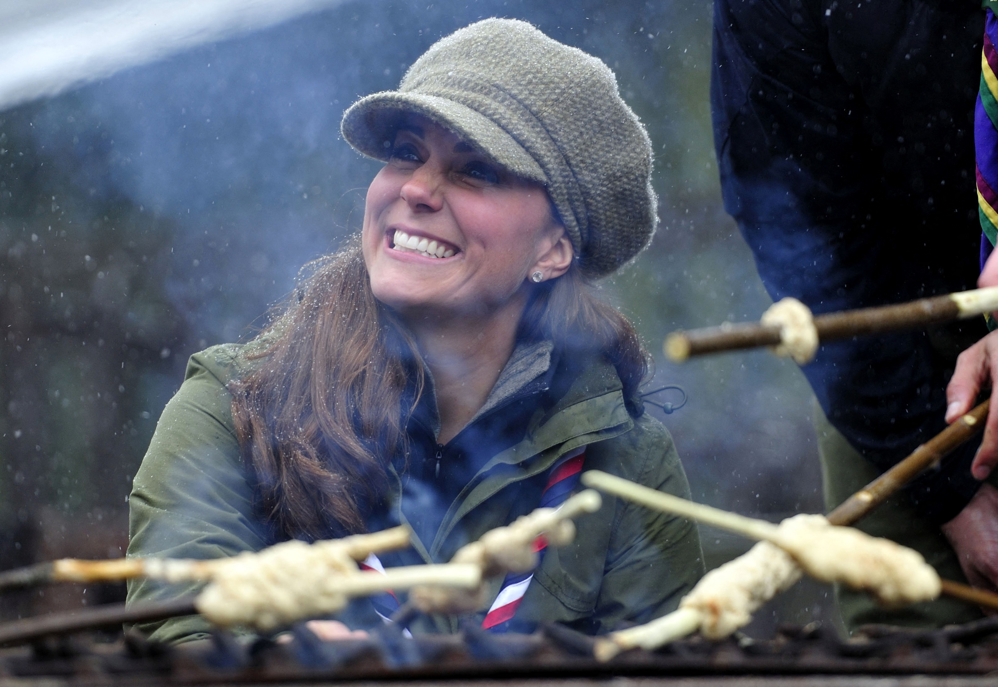 Catherine, Duchess of Cambridge joins in the preparation of campfire food during a visit to the Great Tower Scout camp