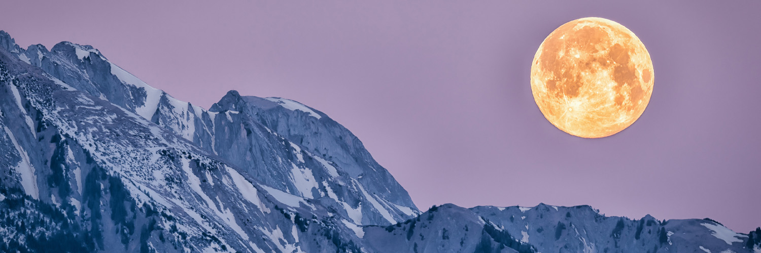 full moon over a mountain range