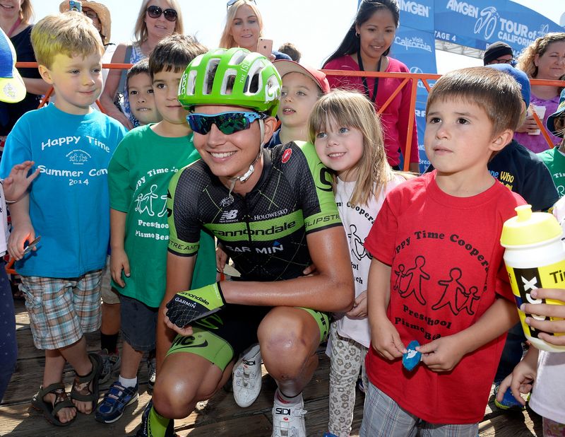 Joe Dombrowski poses with the kids before the start of the stage