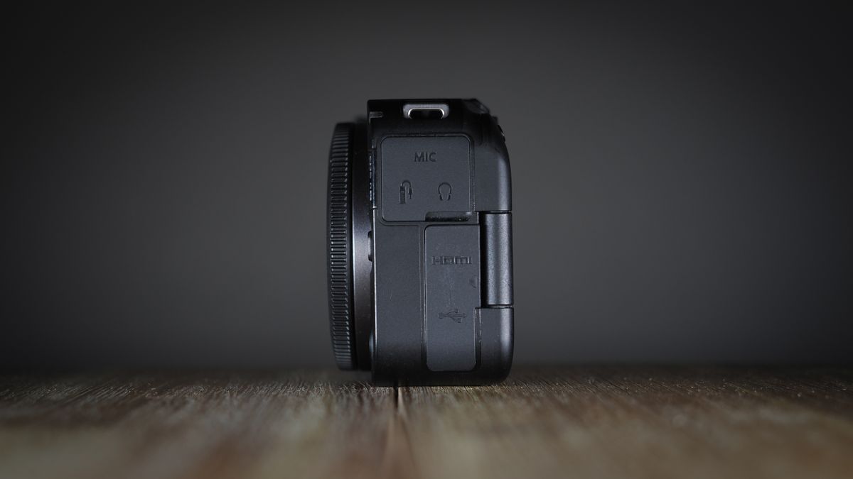 Canon EOS R50 V on a wooden surface, against a dark background