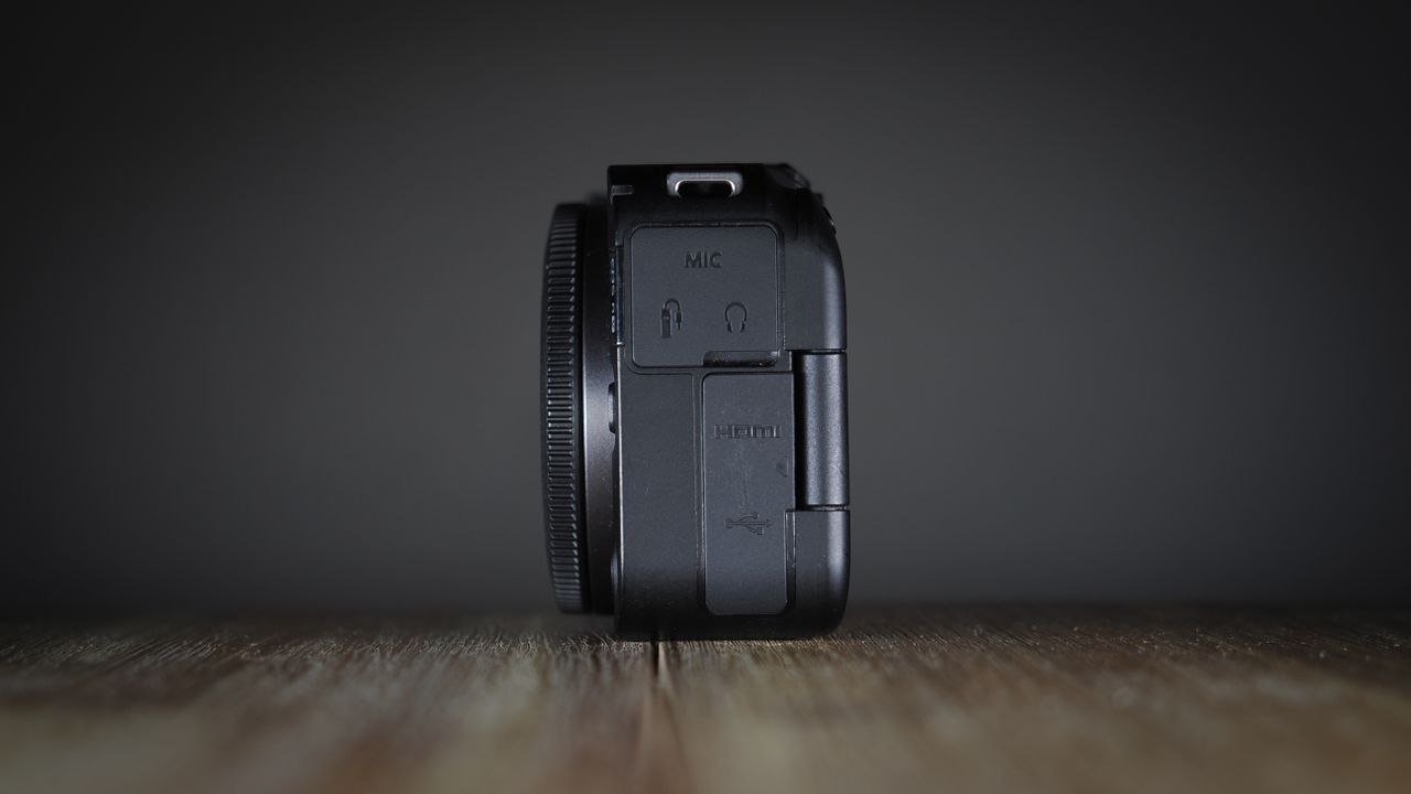 Canon EOS R50 V on a wooden surface, against a dark background