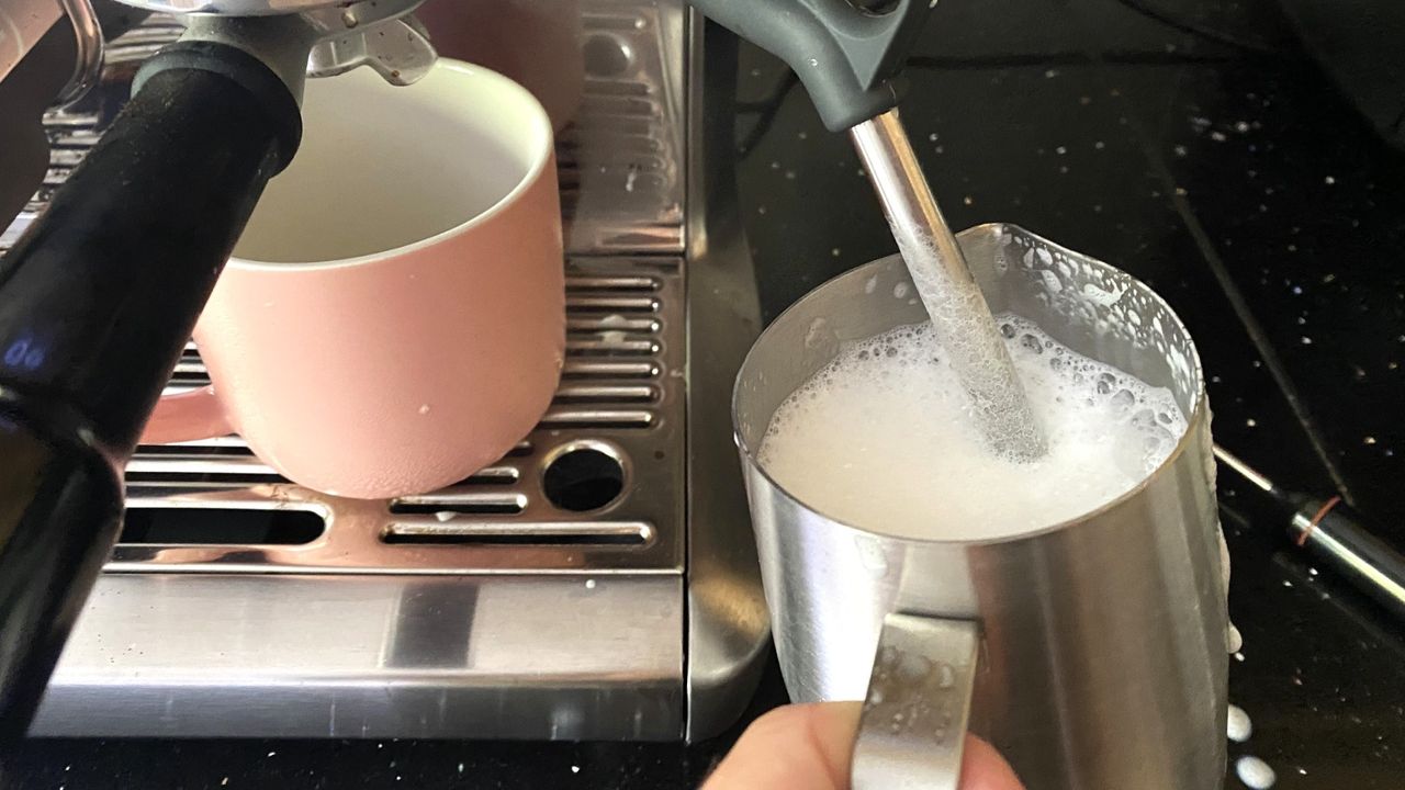 Breville Barista Express Impress coffee maker on kitchen counter