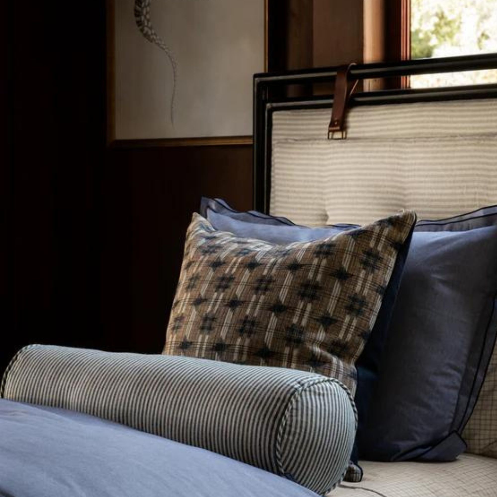 A twin bed with three throw pillows