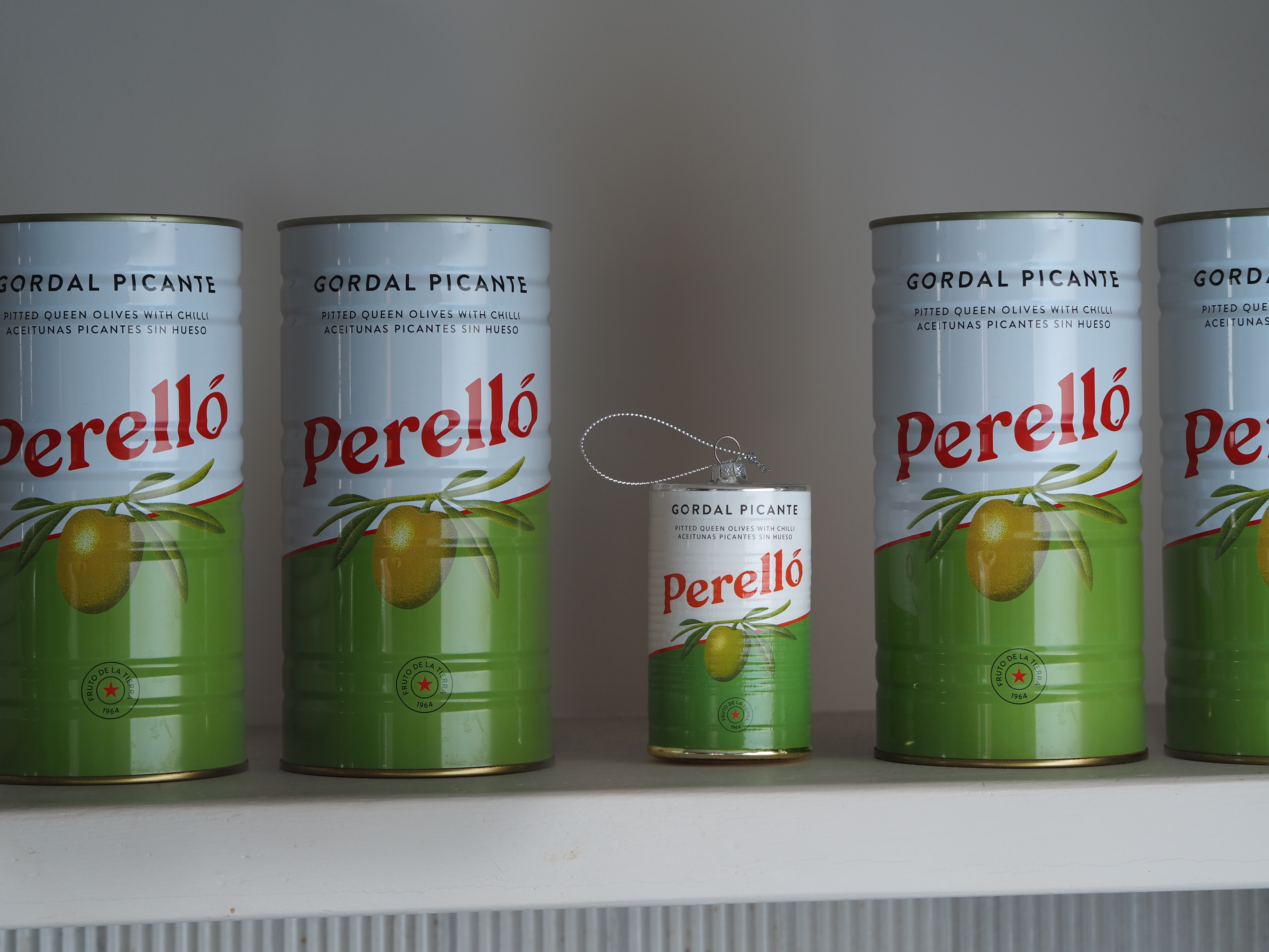 tins of perello olives with a small decoration between