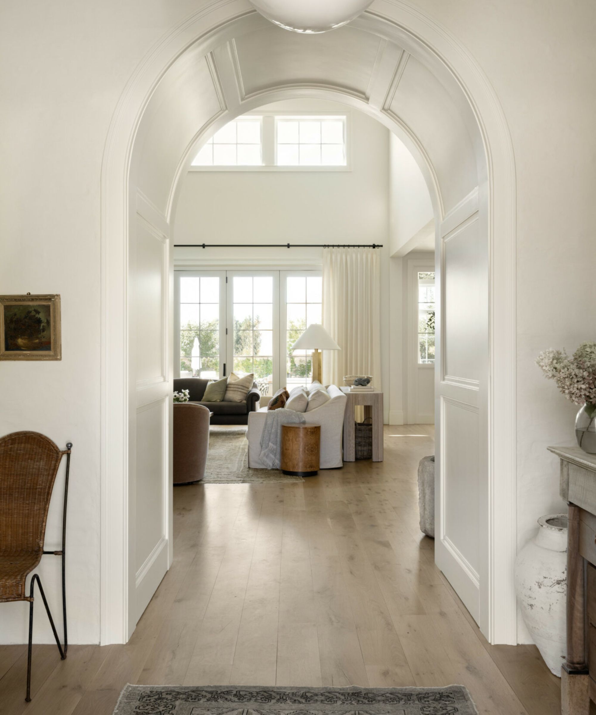 open plan archway in Shea McGee's home painted white with traditional moldings