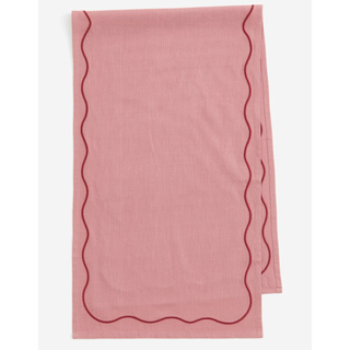 pink table runner with a red wavy border