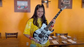 Maya Neelakantan holding the jeff hanneman signature model in a restaurant