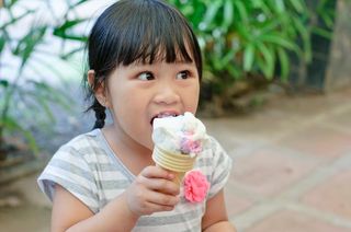 asian girl eating an ice cream cone.