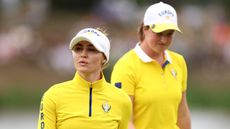 Charley Hull and Lottie Woad walk off the green
