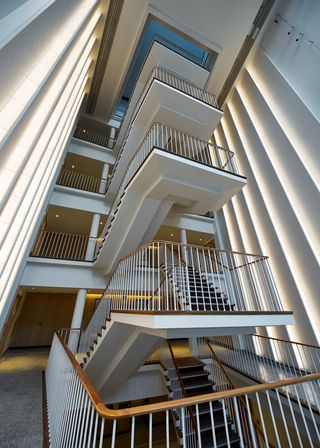 White staircase with dark wooden handrail