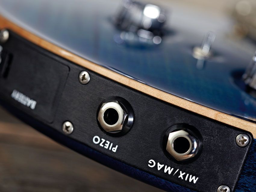 Plugging another mono lead into the piezo output means you can send each signal to separate amps