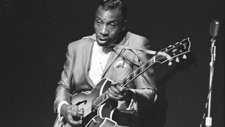 A black-and-white archive photo of T-Bone Walker playing his Gibson Barney Kessel