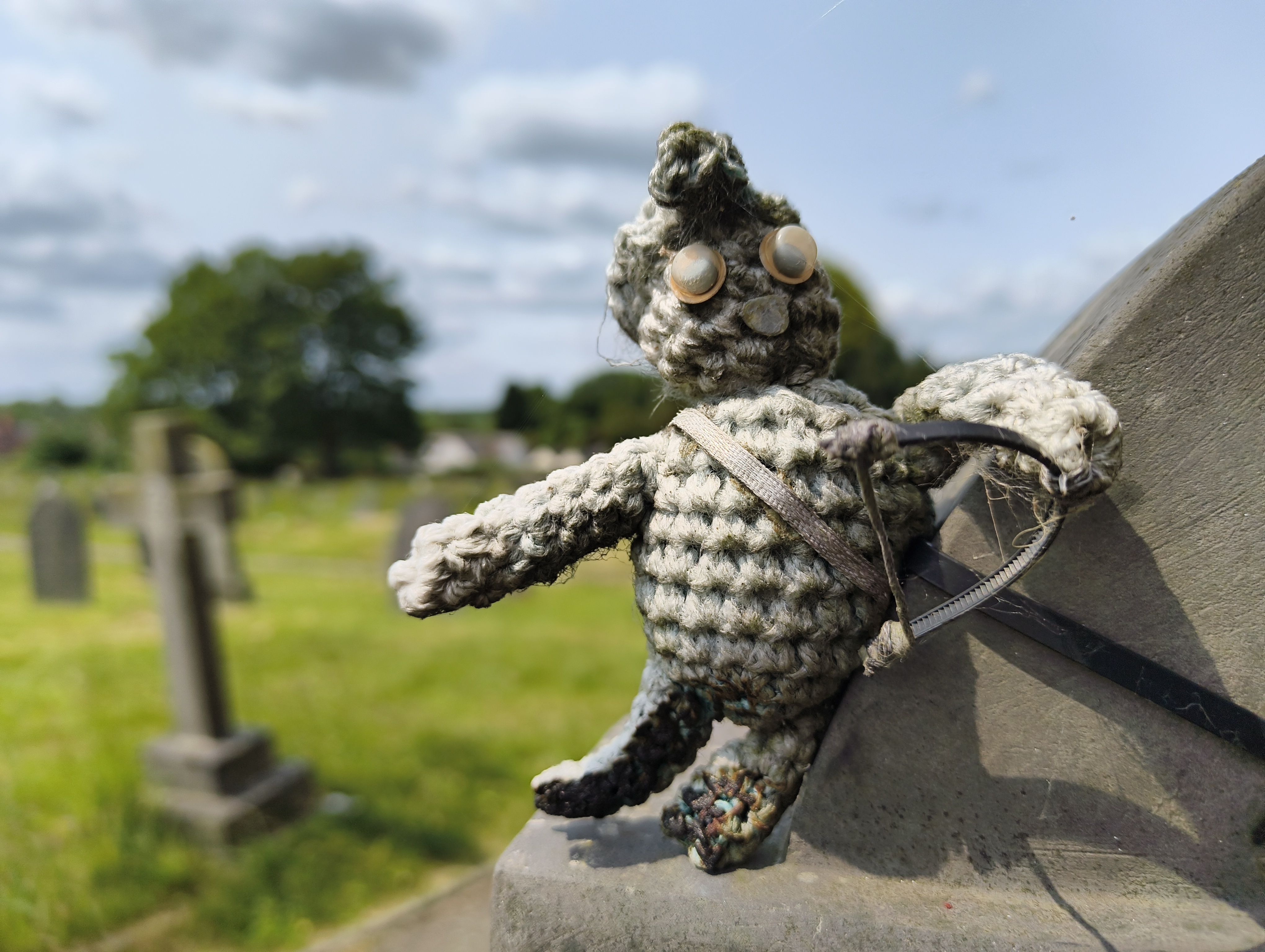 Close-up of a knitted toy on the edge of a stone