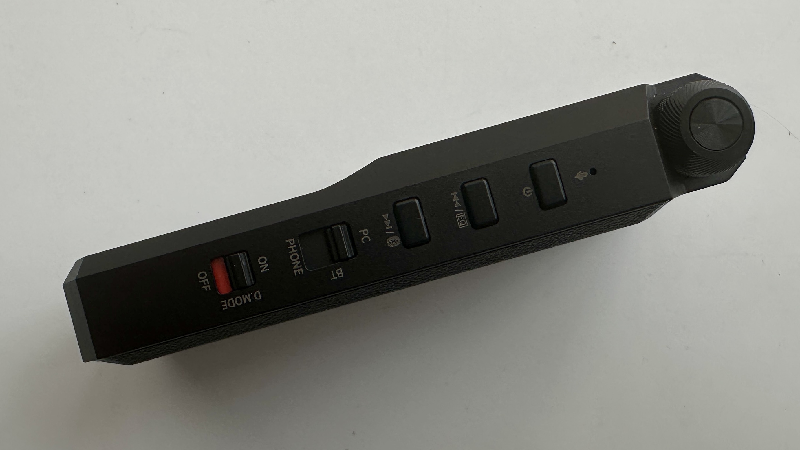FiiO's BTR17 DAC/amp in black, on a gray table, showing PCM resolution in yellow font
