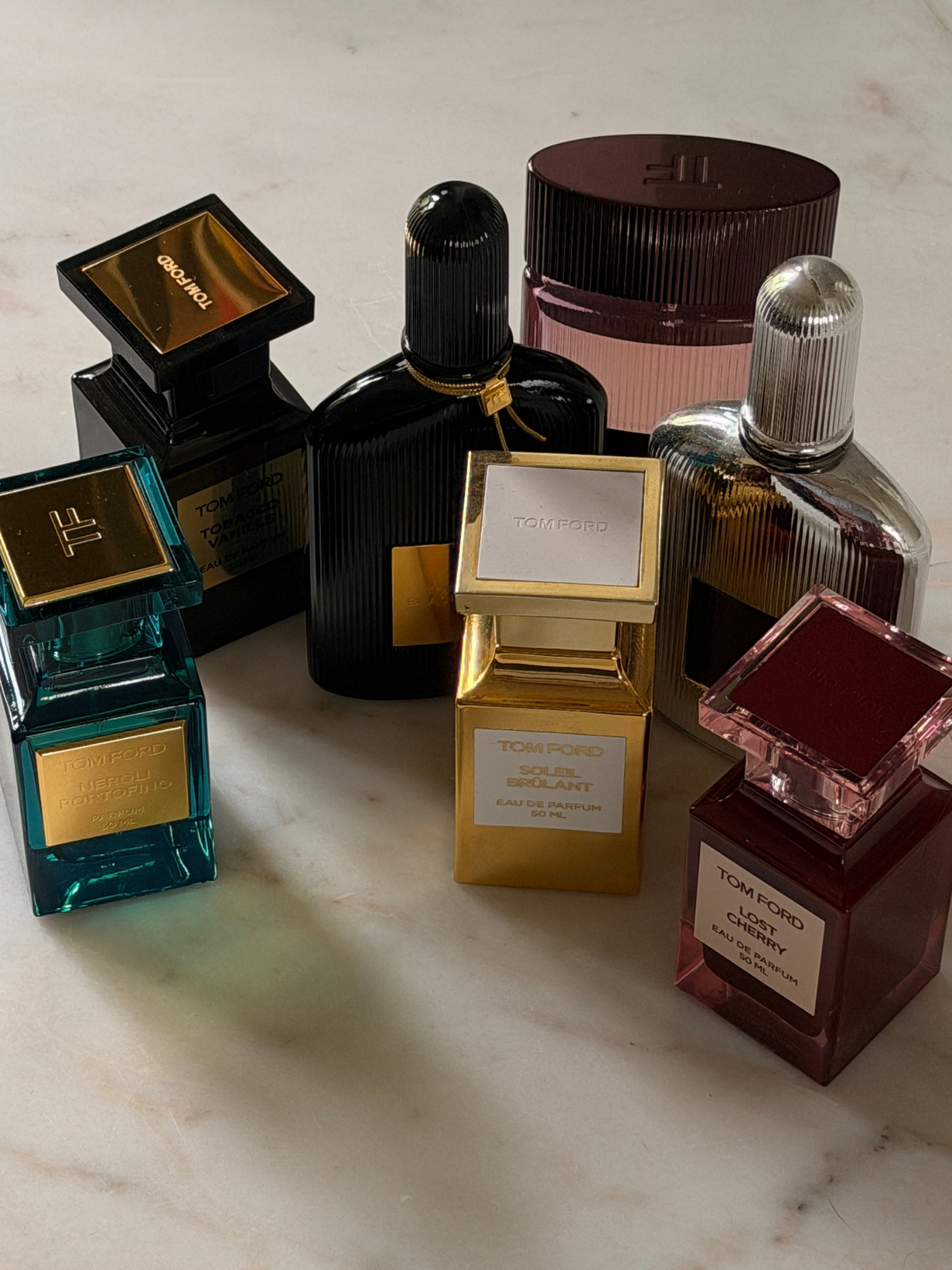 A selection of Tom Ford fragrances on a marble surface