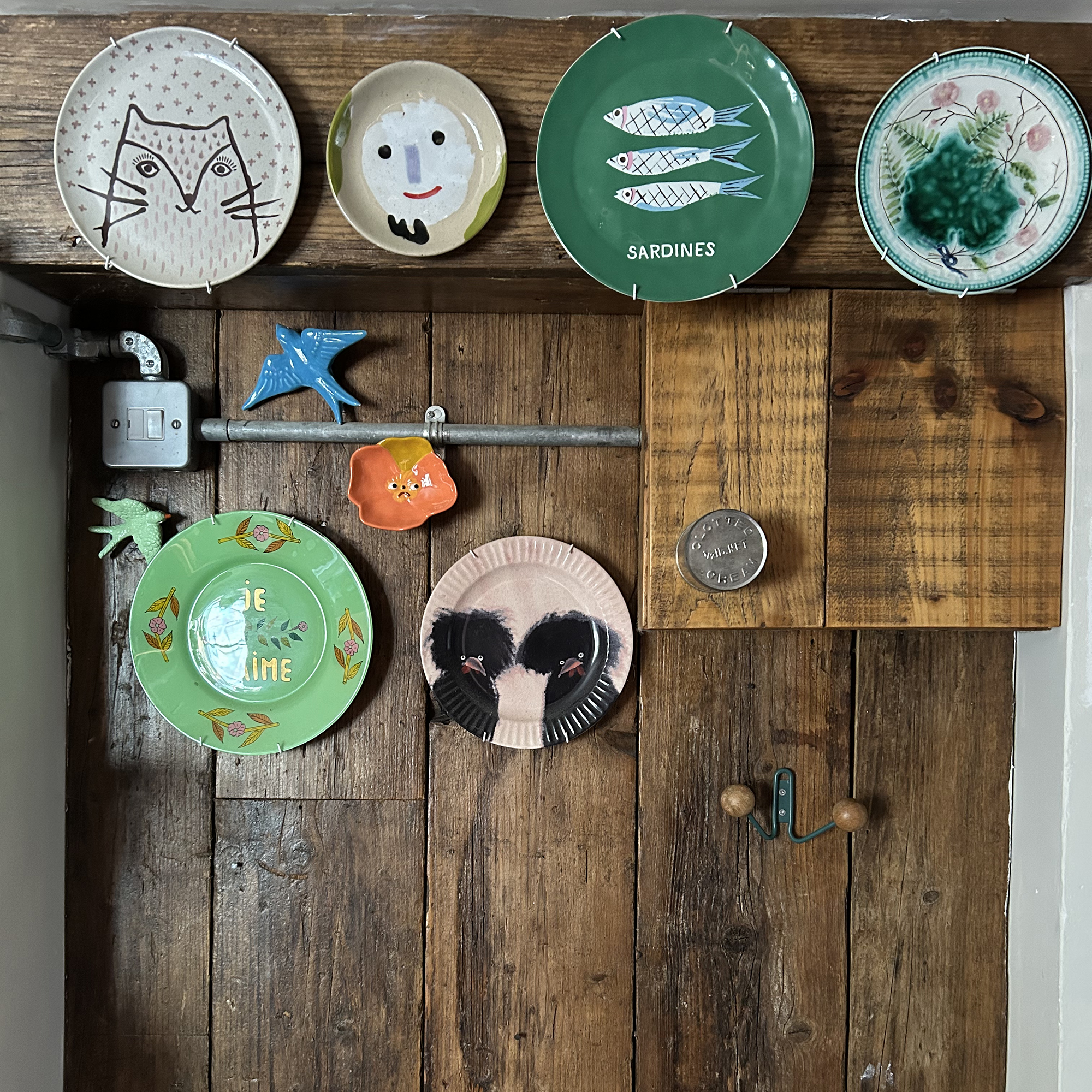 An assortment of decorative plates displayed on a wooden wall