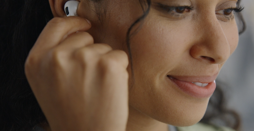 Woman fixing AirPods Pro 2, one of the best Apple headphones, into her ear