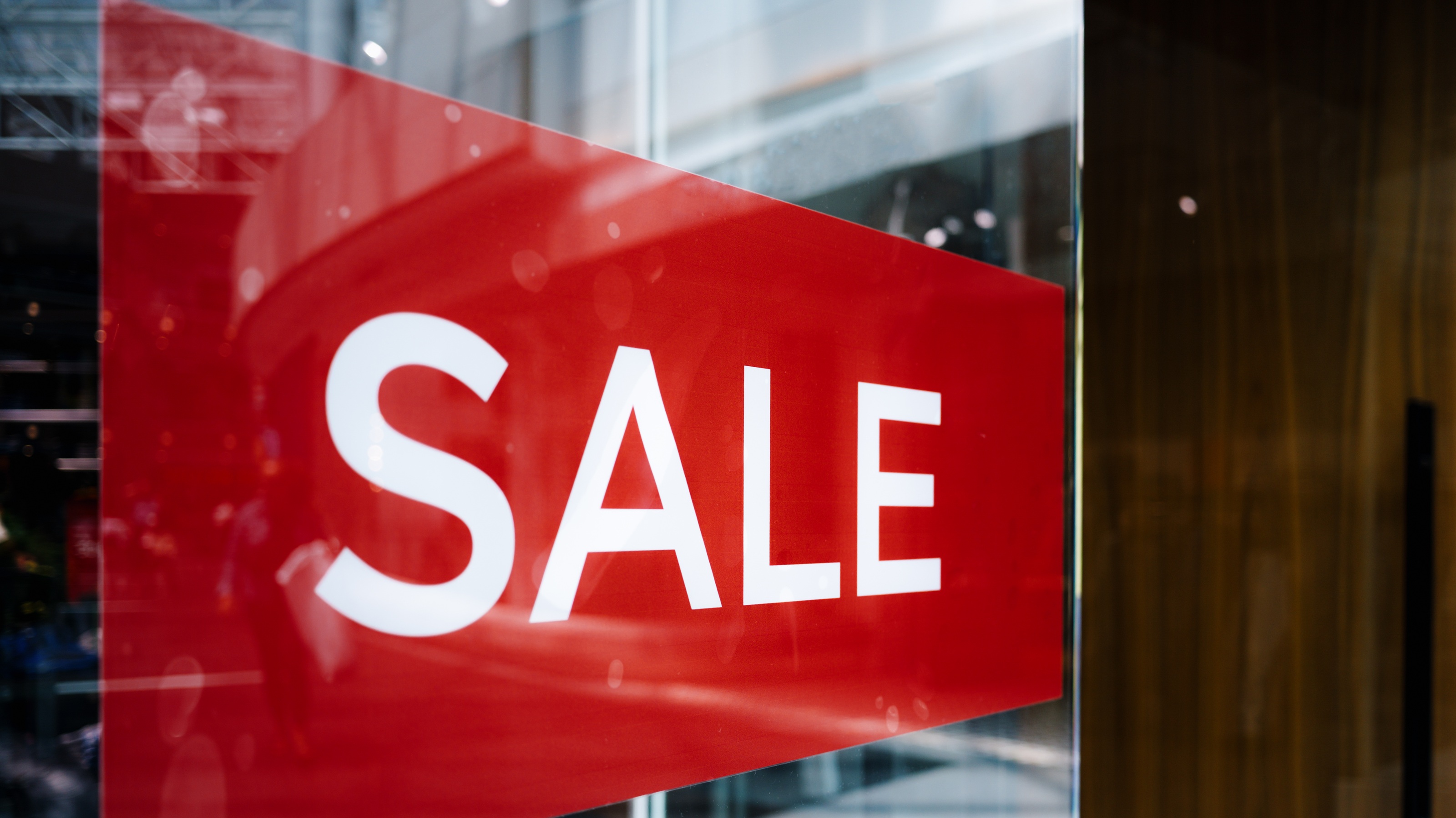 A big red sale sign in a store window.