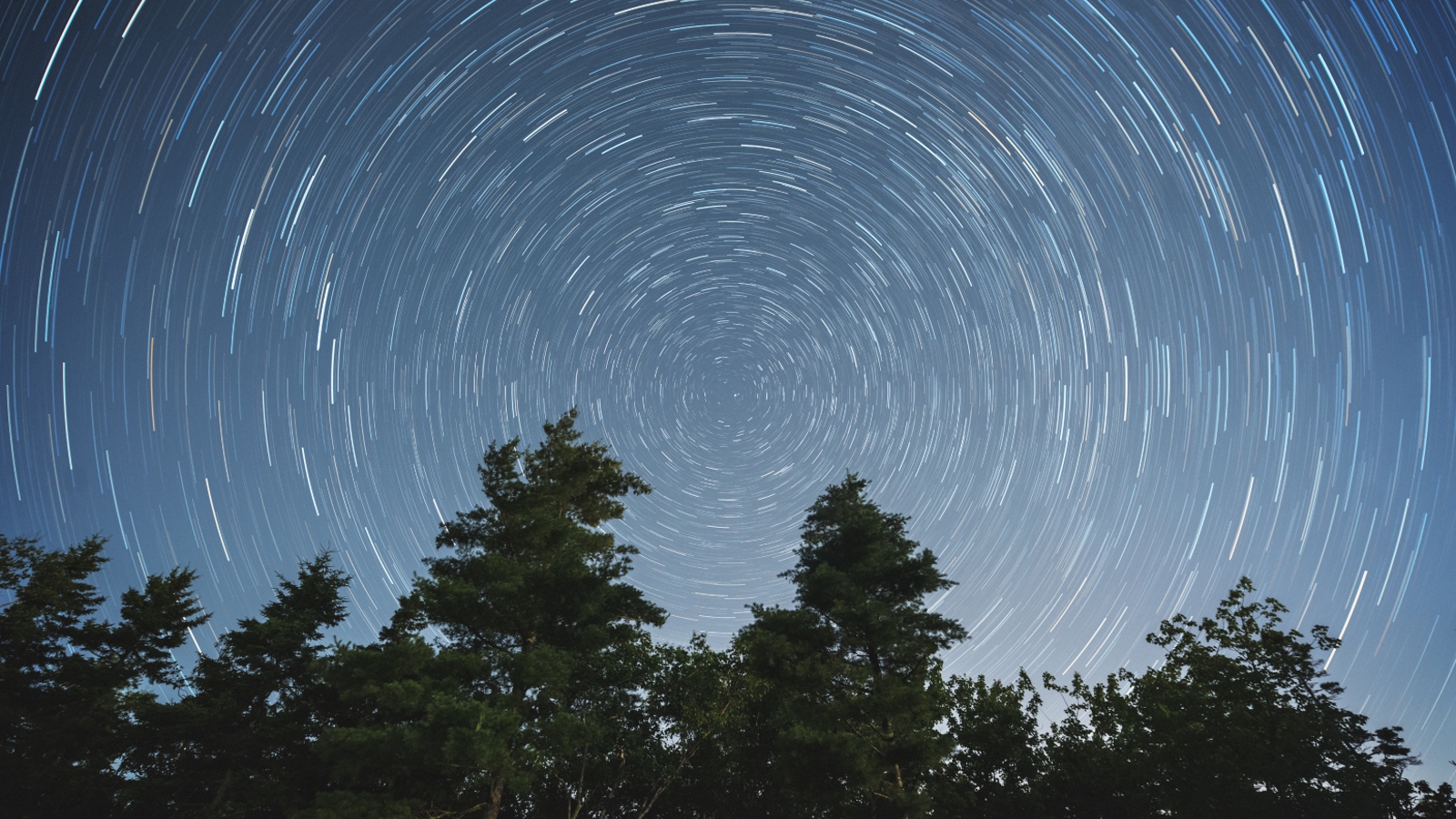 Líneas estelares en espiral en el cielo nocturno causadas por la rotación de la Tierra