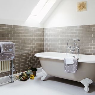 attic bathroom with bathtub and ceramic flooring