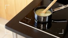 induction hob with stainless steel saucepan heating soup to support an expert guide on how to clean an induction hob