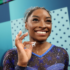 Gold medalist Simone Biles of Team United States poses with a necklace in the likeness of a goat after competing in the Artistic Gymnastics Women's All-Around Final on day six of the Olympic Games Paris 2024 at Bercy Arena on August 01, 2024 in Paris, France