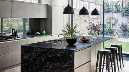 black kitchen island with drawers and pendant lights