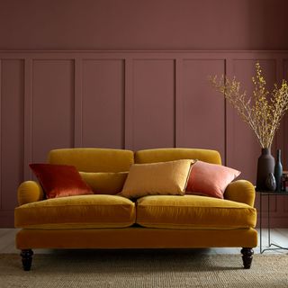 living room with red wall and brown sofa