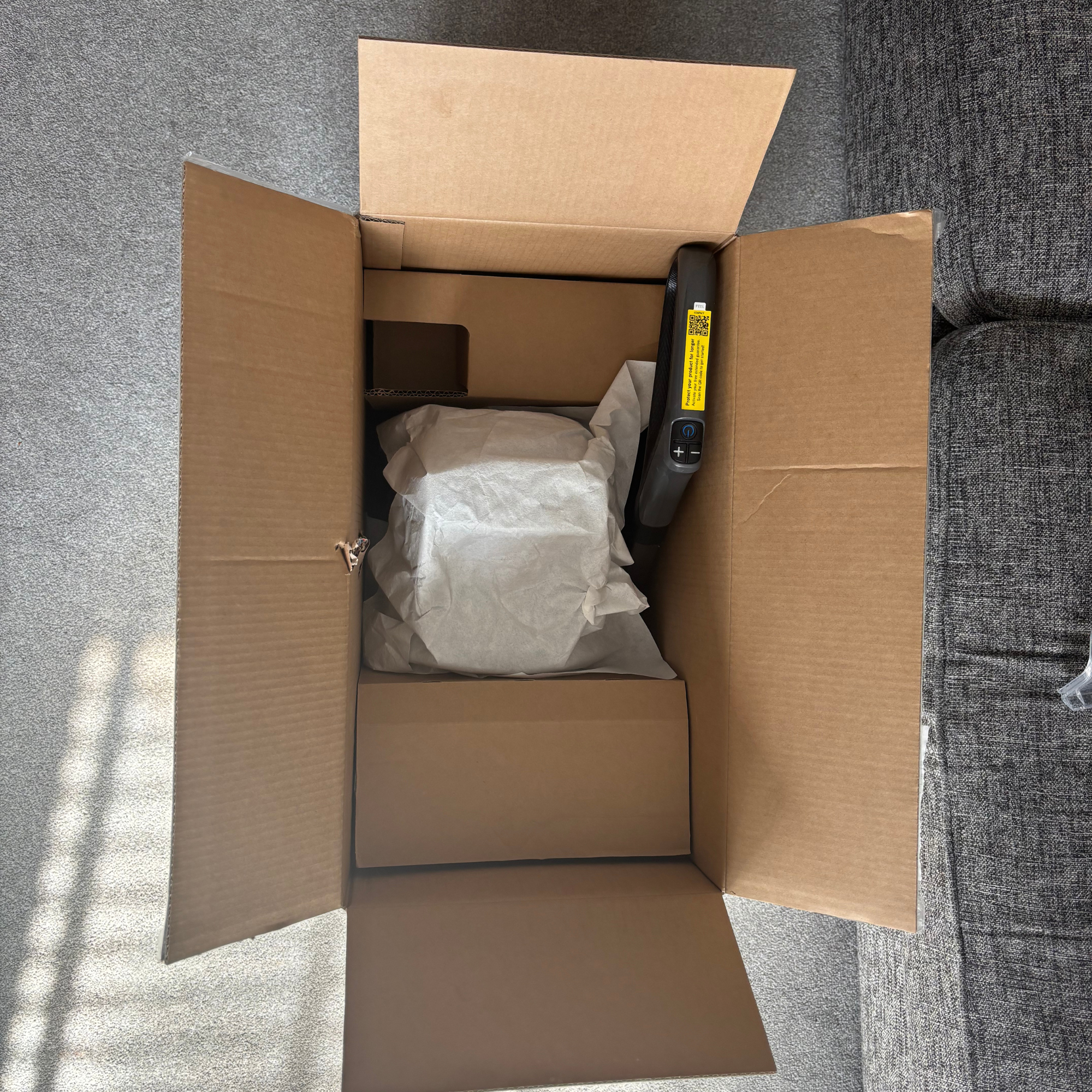 Inside view of opened cardboard box with carpet washer contents neatly packaged inside 