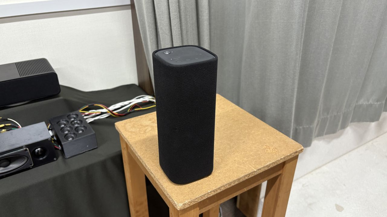 Yamaha True X Surround 90A system (soundbar, surround speakers and subwoofer) in a plain testing room with a TV.