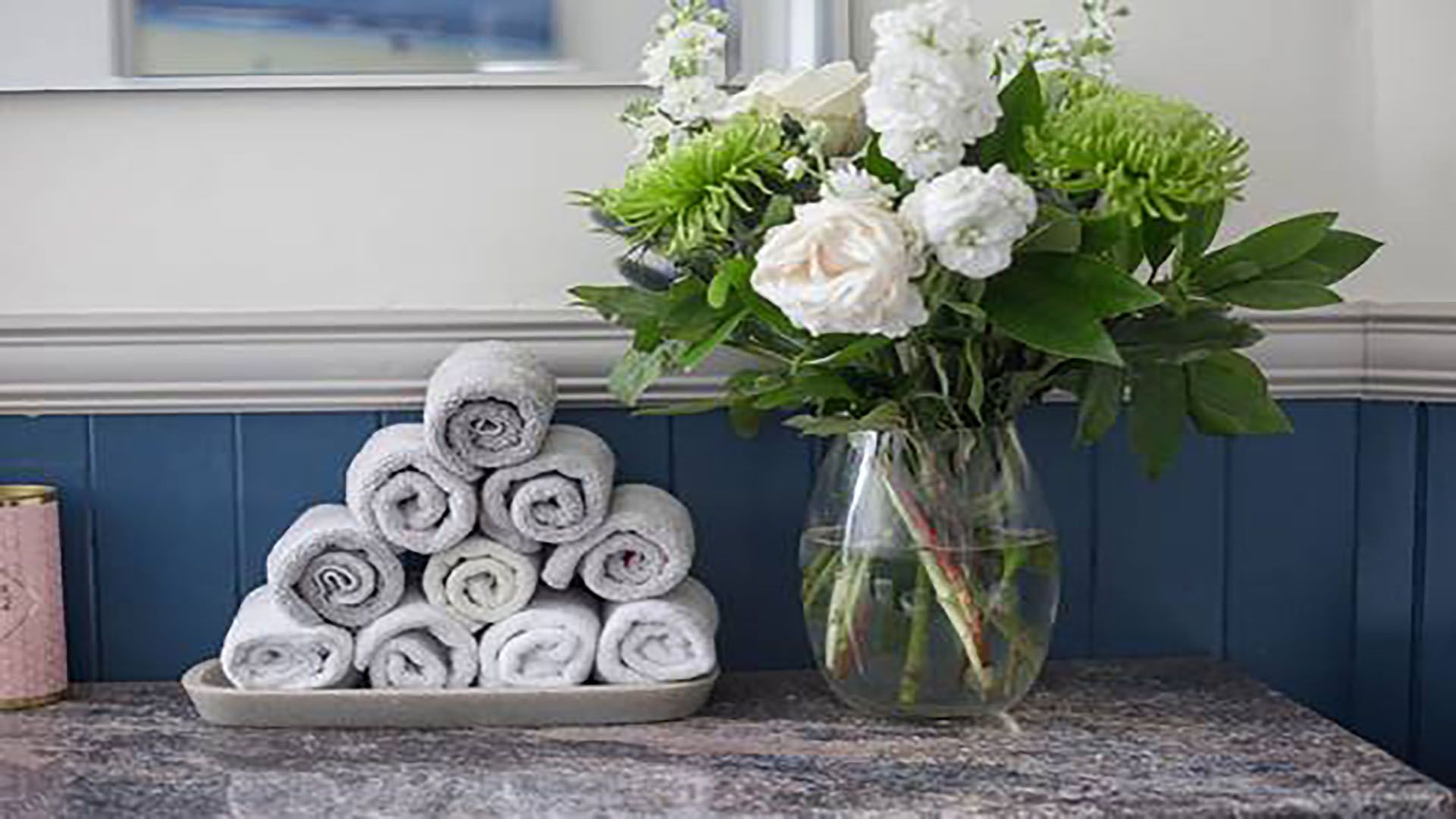 clean decluttered bathroom with towels rolled up on the side