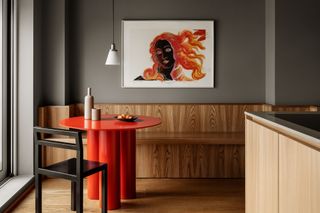 a dining room with wood paneling and a red table