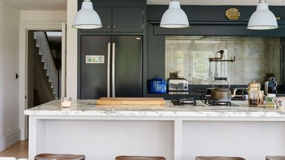 black kitchen with island and large refrigerator