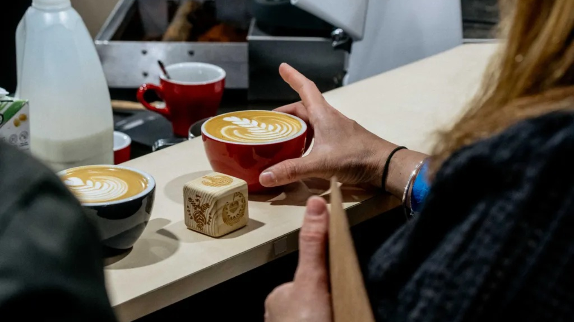 A hand holding a coffee at The London Coffee Festival  