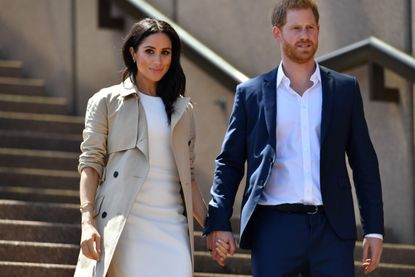 A close-up of Harry and Meghan walking down some steps